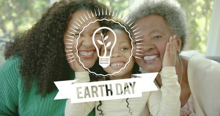 Smiling three-generation family pressing faces together on couch at home, showing Earth Day overlay. Multigenerational, greenery, sunlight, cozy, livingroom, interior, sustainabilityの写真素材