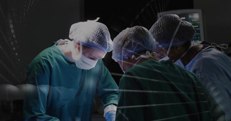 Operating team in gowns and masks performing surgery, using instruments and watching vital monitor. Operation, scalpel, forceps, anesthesia, hospital, sterile, lightingの写真素材