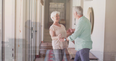 Holding hands couple, woman wearing pink top, man wearing green shirt in hallway with runner rug. Senior, pair, corridor, home, mirror, daylight, warmthの写真素材