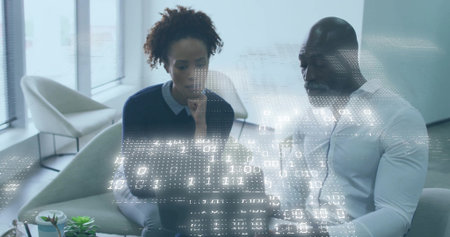 Colleagues working on laptop in lounge, woman dark sweater, man white shirt, viewing binary overlay. Office, collaboration, analytics, data, holographic, minimalist, modernの写真素材