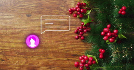 Showing green garland with red berries and tinsel on wood desk, copy space. Evergreen, holly, wreath, foliage, decor, festive, seasonalの写真素材