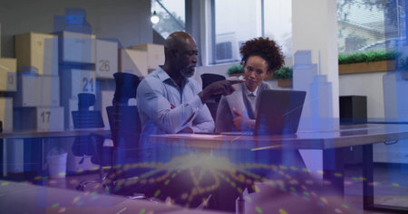 Pointing duo in blue shirt, grey blazer using laptop at office table boxes17,21,26 and data overlay. Colleagues, collaboration, meeting, workplace, modern, visualization, planningの写真素材
