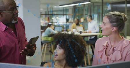 Listening woman with curls wearing sleeveless top looking up at man holding tablet in open office....