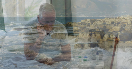 Sitting senior man wearing light polo holding head at home, with pills and cane overlay. Contemplative, layered, muted, elderly, curtain, mugの写真素材