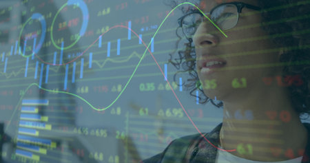 Viewing man with glasses and dark blazer studying transparent market display at office, copy space. Candlesticks, trading, finance, dataviz, analytics, focus, workspaceの写真素材