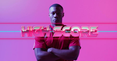 Standing adult man wearing athletic shirt posing in studio, neon HIGH SCORE overlay....