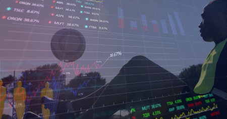 Standing field worker wearing reflective vest overlooking trees with market charts, copy space. Datavisualization, outdoor, doubleexposure, neon, analytics, finance, silhouetteの写真素材