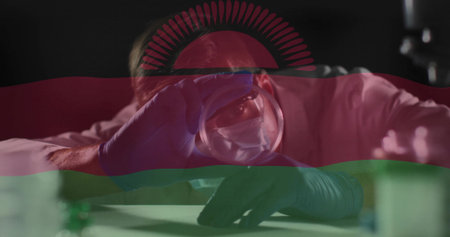 Leaning scientist holding glass sphere to eye at lab bench, white coat, blue gloves. Researcher, vessel, laboratory, investigation, focus, curiosity, tintedの写真素材