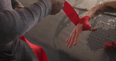 Trainer wrapping partner's wrist at gym, wearing workout gear, with red wrap and halftone overlay. Closeup, forearm, bandage, studio, athlete, training, preparationの写真素材