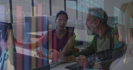 Pointing woman in sleeveless blouse and man discussing data on monitor and laptop in office....
