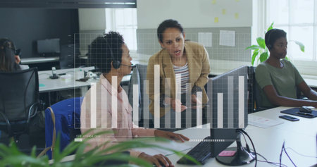 Leaning, supervisor in beige blazer guiding agent with pink blouse and headset at office, chart HUD. Collaboration, teamwork, leadership, guidance, training, mentoring, productivityの写真素材