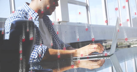 Coding man plaid shirt sleeves rolled typing on laptop by windows with binary overlay, copy space....