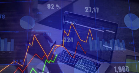 Analyzing analyst in dark blouse reviewing laptop at office desk, with charts phone overlays. Data,...