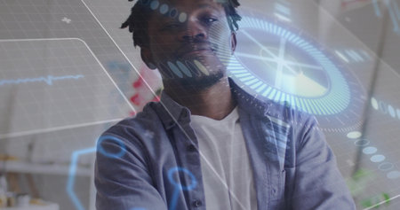 Standing mid adult man wearing white T-shirt and gray shirt, viewing AR HUD graphics in studio. Futuristic, overlay, interface, technology, workspace, focus, concentrationの写真素材