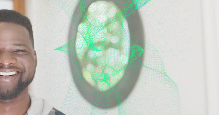 Smiling man wearing gray hoodie facing forward at home wall, with mirror, green mesh, copy space. Portrait, sweatshirt, casual, interior, ambient, digital, reflectiveの写真素材