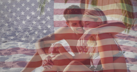 Sitting couple embracing on rippled sand, wearing bikini top and swim trunks. Romance, beach, goldenhour, palm, shore, tropical, intimacyの写真素材