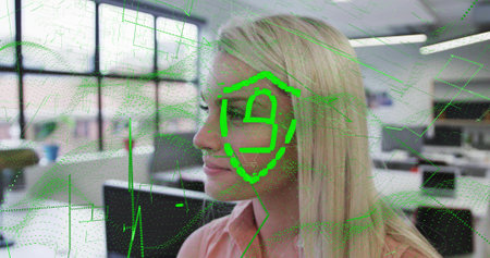 Facing right, woman in light pink blouse showing green shield overlay scanning face in office. Facialrecognition, biometrics, cybersecurity, datavisualization, holographic, workspace, futuristicの写真素材