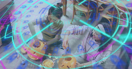 Carving two women wearing casual tops on home wood floor, with pumpkins, bowl, autumn, crafting,...