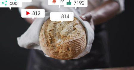 Holding artisan loaf, baker in white shirt and dark apron presenting on cloth. Bread, crust, bakery,...