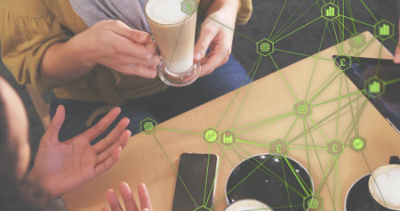 Discussing group holding lattes and devices on cafe table with green overlay mustard top gray scarf....