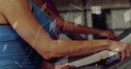 Gripping woman in blue tank exercising on elliptical, with console, yellow knob and digital overlay....