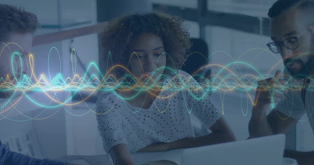 Reviewing three-person team leaning over laptop in office, woman in white eyelet blouse, waveform. Collaboration, colleagues, visualization, analytics, focused, workspace, modernの写真素材