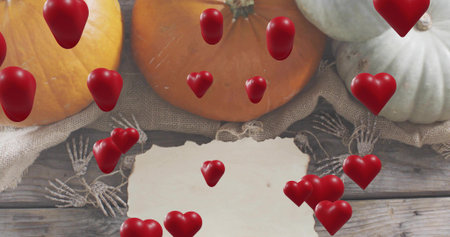 Displaying torn blank paper sitting on wood plank with burlap pumpkins, skeleton hands, red hearts....