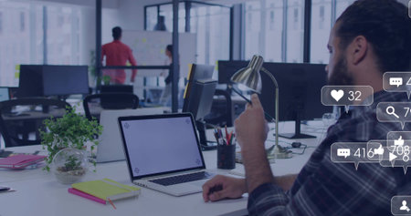 Working bearded man plaid shirt holding phone typing laptop at office with social icons, copy space....