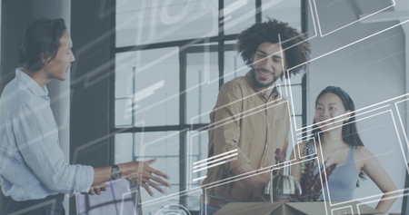 Gesturing man in light blue shirt explaining at office, colleagues unpacking box holding glass vase. Team, workspace, collaboration, modern, openplan, geometric, reflectionsの写真素材