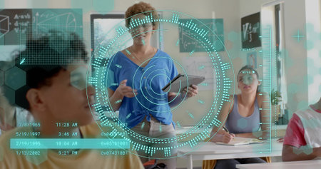 Presenting teacher in blue top holding tablet at classroom front, showing holographic HUD. Instructor, students, learning, education, overlay, augmented, realityの写真素材