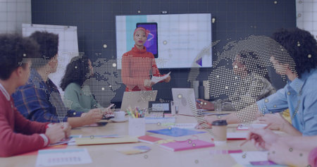 Presenting red-sweater leader addressing team at conference room with display showing smartphone. Boardroom, collaboration, corporate, briefing, laptops, notes, coffeeの写真素材