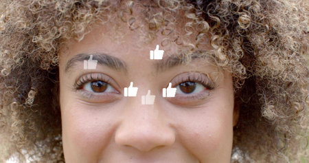 Framing adult female face filling close-up at soft backdrop, with five white thumbs-up icons. Headshot, curls, eyes, lashes, eyebrows, texture, neutralの写真素材