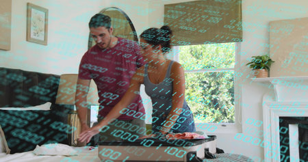 Packing couple leaning over bed at home, arranging clothes in open carry-on suitcase. Luggage, duo, wardrobe, bedroom, daylight, window, interiorの写真素材