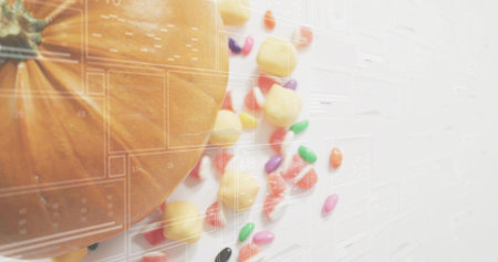 Showing orange pumpkin filling left on white table, candies scattering, grid overlay, copy space. Gourd, stilllife, flatlay, calendar, jellybeans, treats, colorfulの写真素材