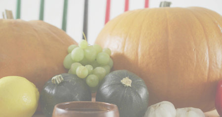 Displaying autumn produce sitting on tabletop, showing pumpkins, grapes, squashes, lemon, garlic. Gourds, grape, citrus, bulbs, rustic, stilllife, kitchenの写真素材