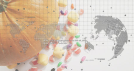 Displaying orange pumpkin and scattered colorful candies on white tabletop, with grid map overlay. Gourd, jellybean, confection, studio, stilllife, infographic, editorialの写真素材