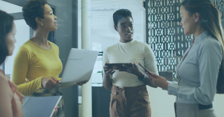 Speaking midcareer woman holding tablet in business-casual presenting in office meeting with laptop. Coworkers, corporate, modern, workplace, glass, sunlight, collaborationの写真素材