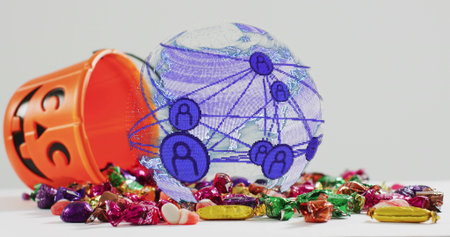 Showing translucent globe over white tabletop, orange jack-o'-lantern candy bucket spilling candies. Holographic, sweets, halloween, pumpkin, flatlay, colorfulの写真素材