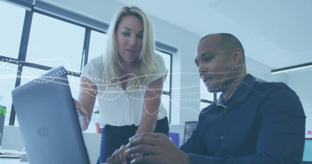 Statistical data processing over male and female supervisors high fiving each other at warehouseの写真素材