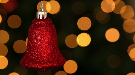 Red glitter bell ornament is hanging in 3D render with silver cap, bokeh lights. Festive, holiday, decoration, celebration, shimmer, luxury, cheerfulの写真素材