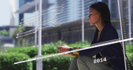 Sitting woman in navy blazer on plaza bench, holding phone with data overlays, copy space....