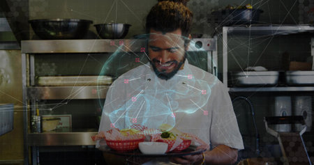 Bearded chef in white coat presenting tray at kitchen, with checked baskets. Plating, culinary,...