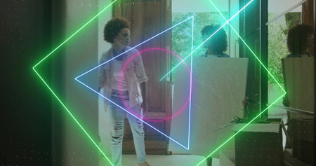 Arranging mid-adult women positioning large white board in foyer, barefoot ripped jeans neon lights....