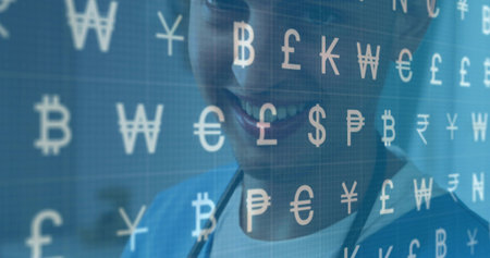 Smiling doctor in blue scrubs with stethoscope viewing screen in clinic showing currency symbols....