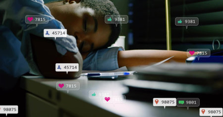 Sleeping woman wearing blue shirt with rolled sleeves at desk with smartphone and reaction icons. Latenight, focus, study, work, learning, solitude, ambienceの写真素材