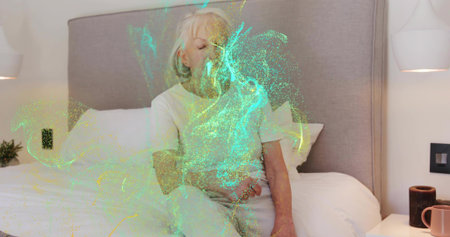 Sitting senior woman wearing light sleepwear resting on bed in bedroom, with green aqua swirl....