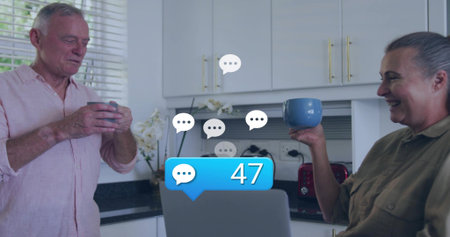 Holding blue mugs, man wearing pink shirt and woman wearing olive shirt smiling at laptop, 47....