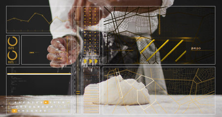 Kneading chef in white coat, patterned apron, pressing floured dough ball in kitchen. Bakery, baker,...