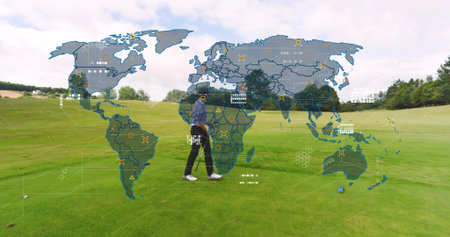 Walking male golfer wearing cap and jacket carrying golf club crossing fairway. Outdoor, lone, grass