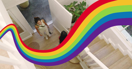 Chatting two women standing in foyer near open white door, wearing white sneakers, rainbow graphic....